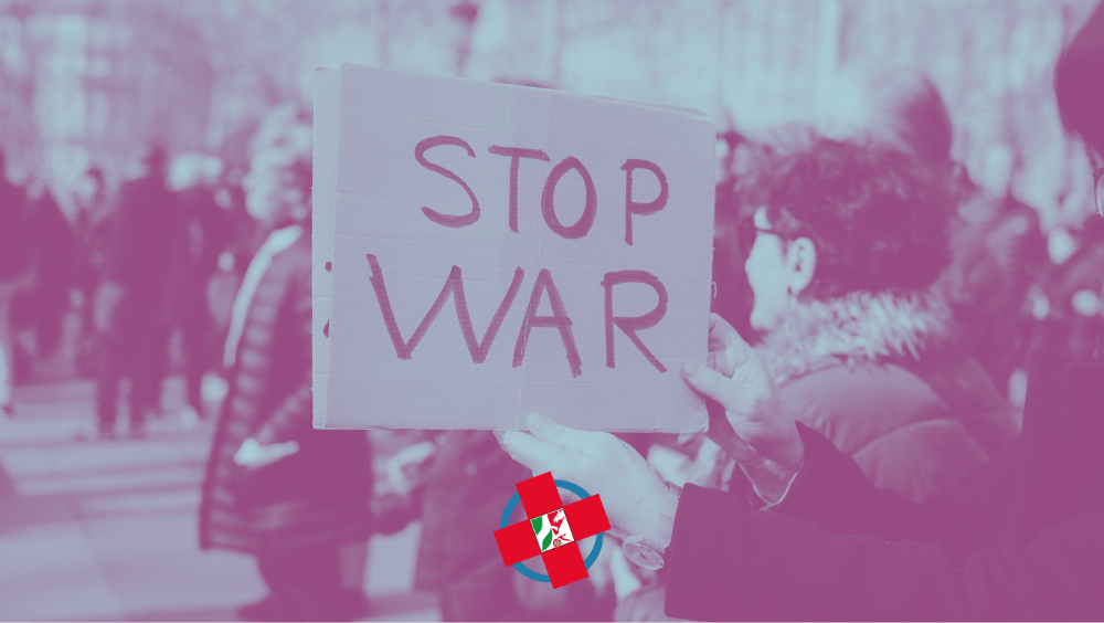 Eine Person hält ein Schild hoch auf dem "Stop War" steht
